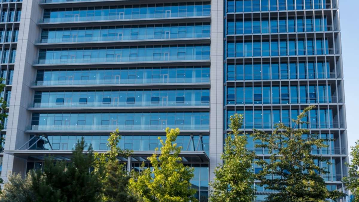 Modern office building with a glass facade, property management insurance
