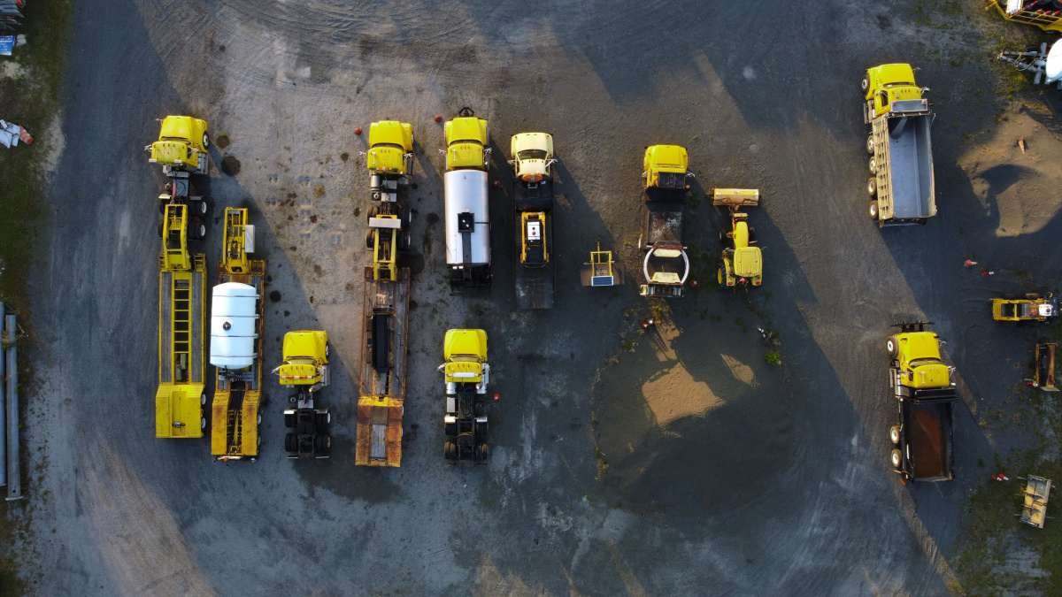 Rows of yellow trucks and machinery on an equipment yard, equipment dealership insurance