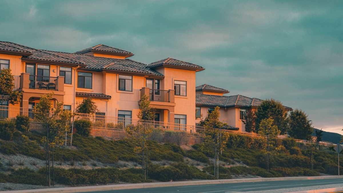 Two-story condominium buildings above a landscaped slope, condo association insurance