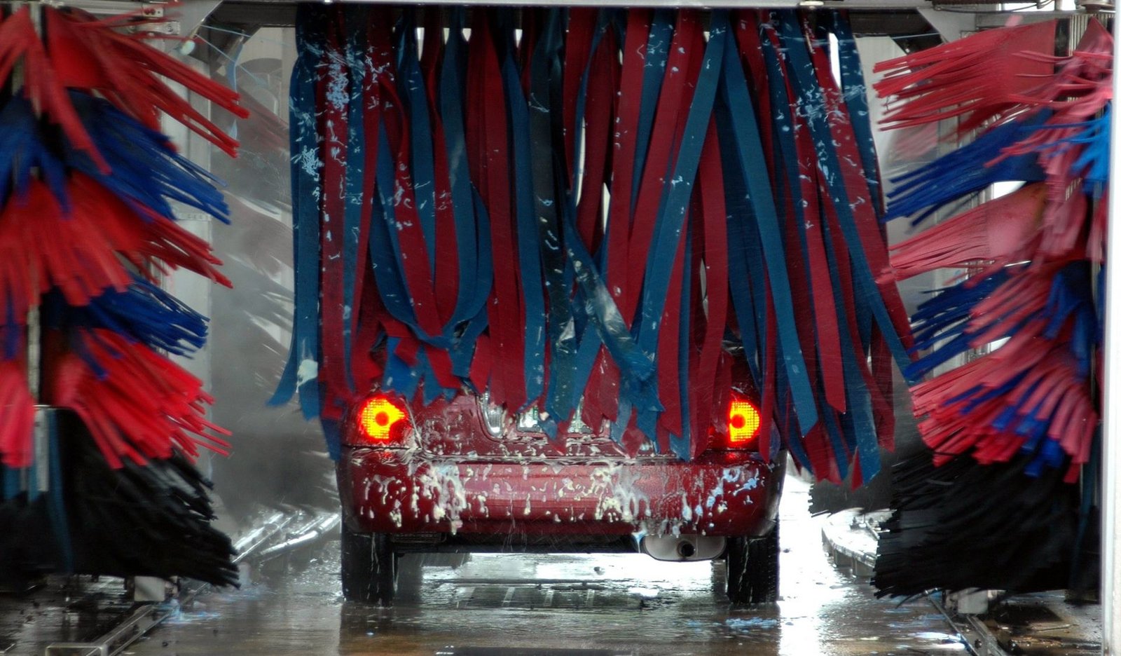 Car passing through the cloth brushes of a tunnel car wash, car wash insurance