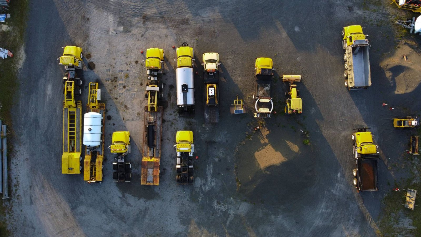 Rows of yellow trucks and machinery on an equipment yard, equipment dealership insurance