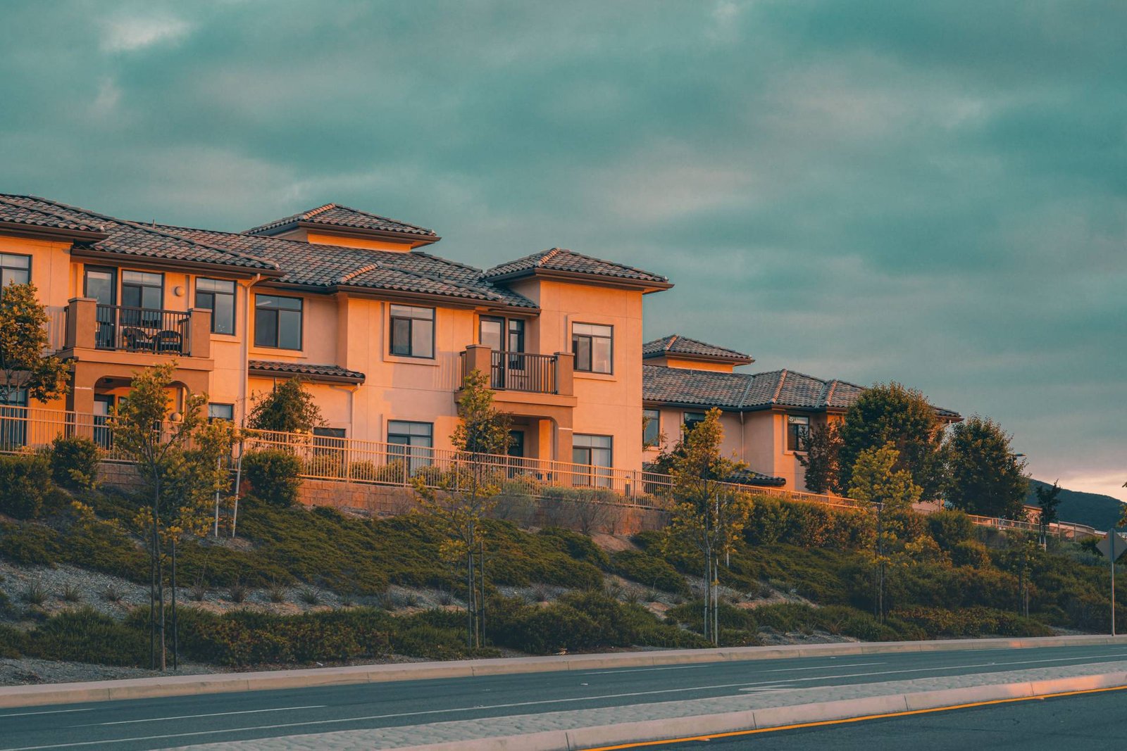 Two-story condominium buildings above a landscaped slope, condo association insurance